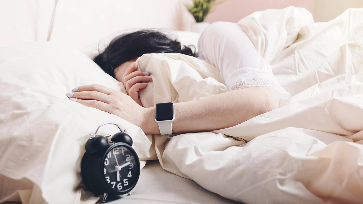 femeie in pat cu apple watch